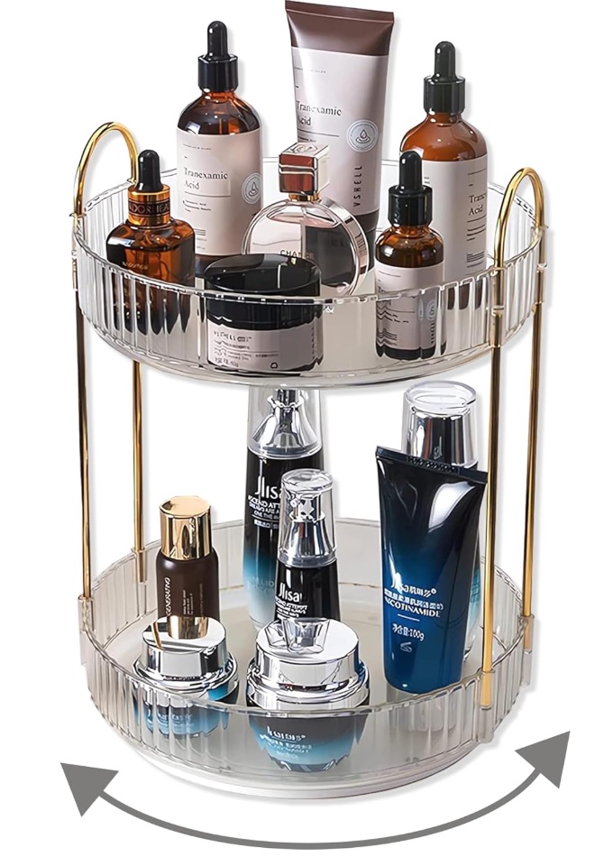 Clear two-tier rotating skincare organizer with gold rails holding bottles and jars.